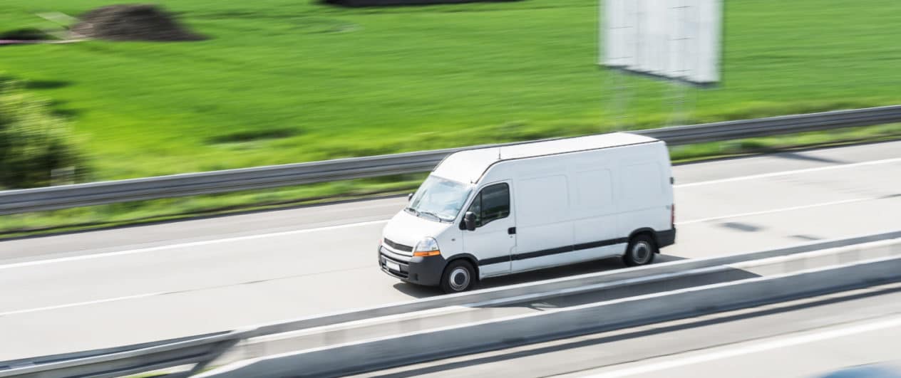 white-delivery-van-in-motion-driving-on-highway-picjumbo-com-e1535731478642